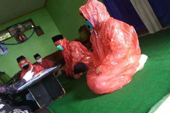 Pasangan Pengantin ini Nikah dengan Menggunakan Masker dan Jas Hujan, Fotonya Viral