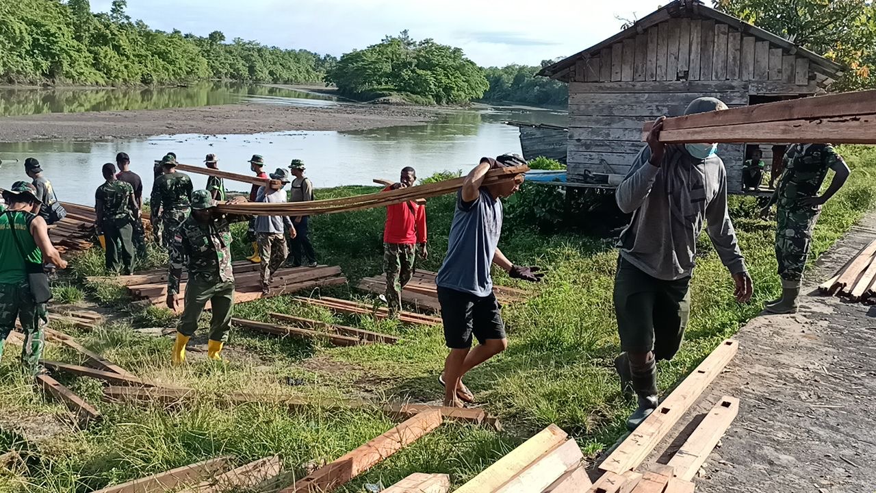 Personel TMMD Kodim 1711 Gotong Royong Bersama Warga Angkut Kayu Untuk Pembangunan Rumah