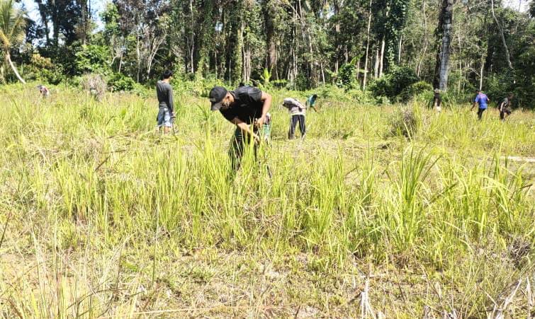 Personel Satgas Yonif 642 Bersama Warga Bersihkan Lapangan Sepak Bola Desa Bungkang