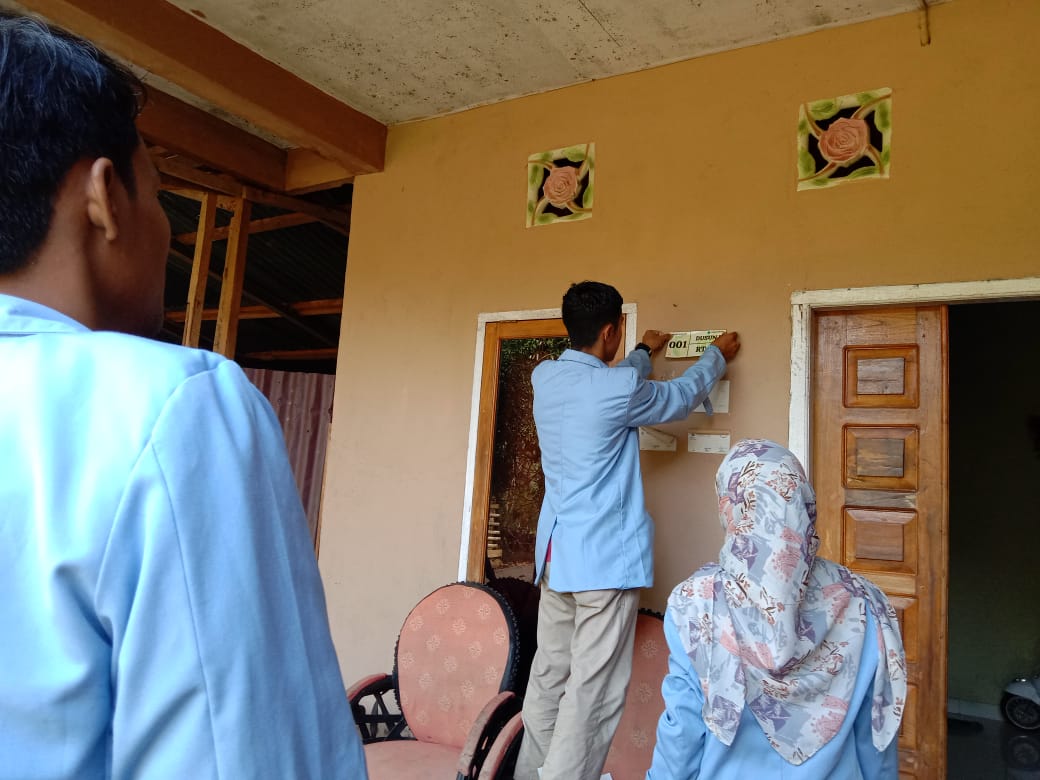 Tim Kukerta Balek Kampung Universitas Riau 2022 Melakukan Pemasangan Nomor Rumah Di setiap Rumah Yang Ada di Desa Pangkalan Kecamatan Pucuk Rantau