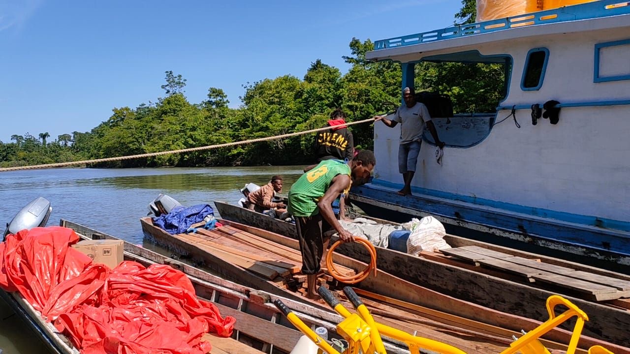 Warga Distrik Kawagit Bantu Longboard Untuk Angkut Material TMMD