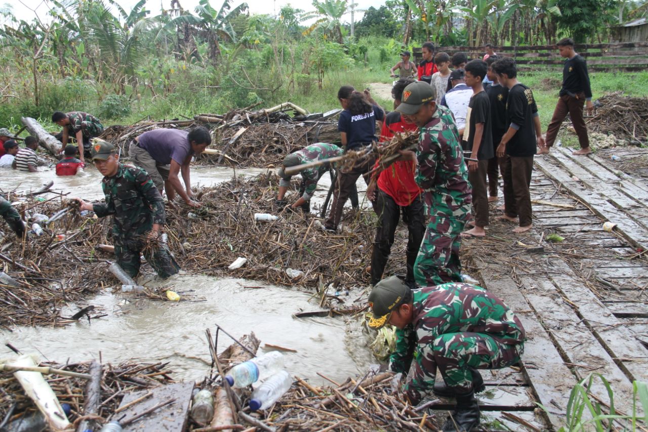 Prajurit Satgas Yonif 131/Brs Bersama Warga Bersihkan Sungai dan Jembatan Akibat Banjir