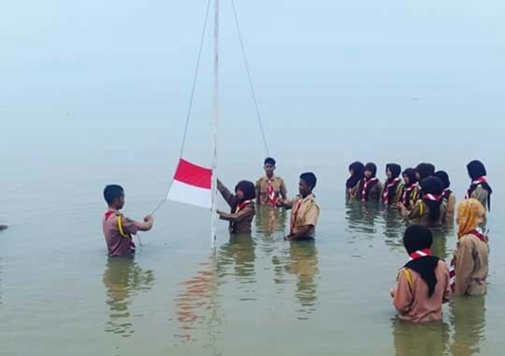 UNIK! Peringati Sumpah Pemuda, Pramuka di Inhil Kibarkan Bendera di Sungai